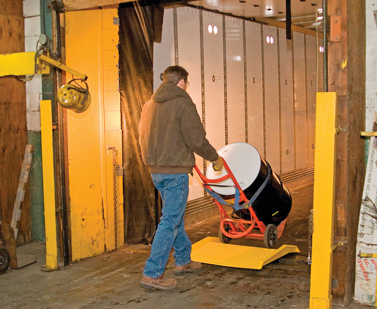 Man uses hand trucks to safely move a 55-gallon drum