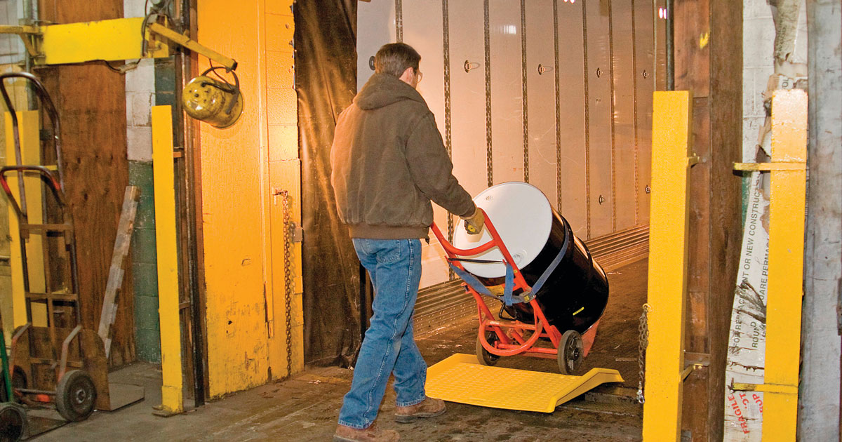 Man uses hand trucks to safely move a 55-gallon drum