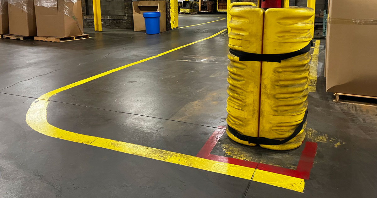 Yellow column protector around column in warehouse
