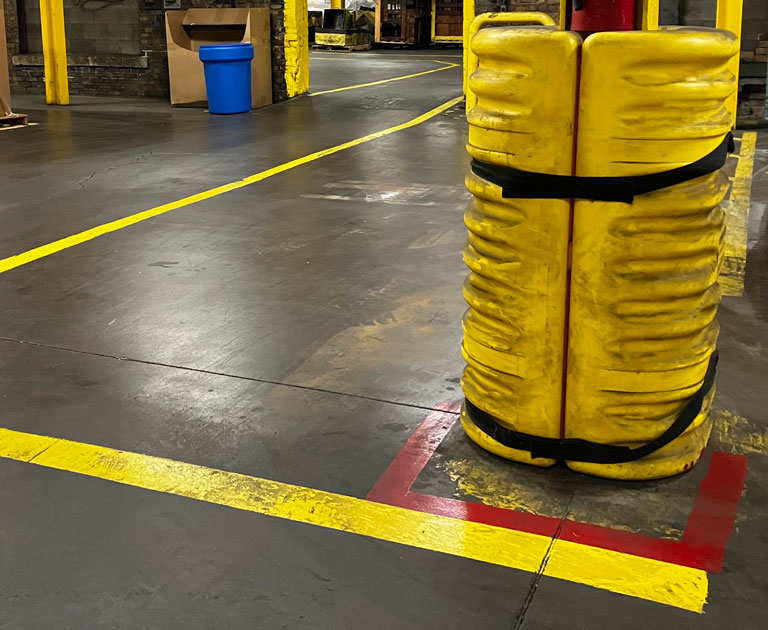 Yellow column protector around column in warehouse