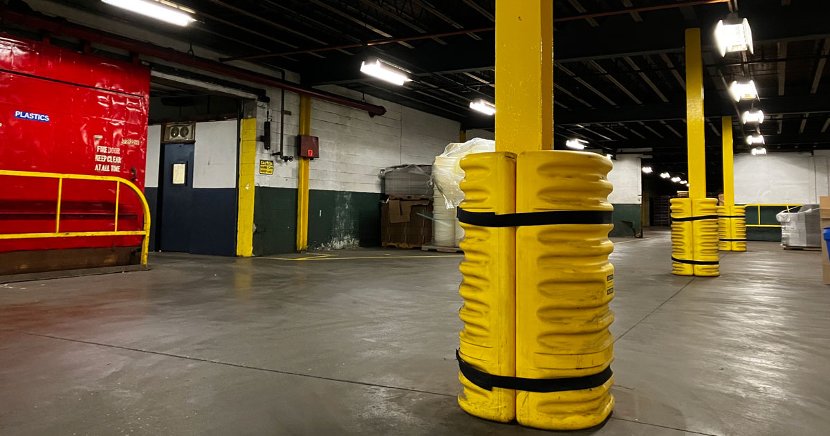 Yellow column protector around pole in large distribution center