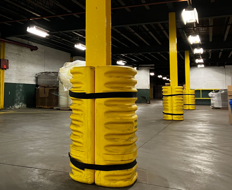 Yellow column protector around pole in large distribution center