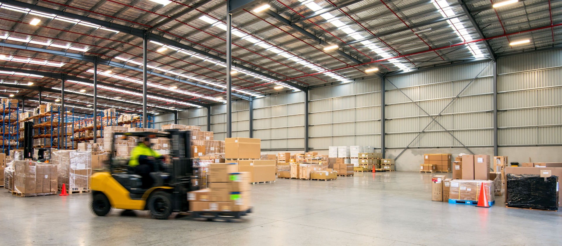 Forklift driving through large warehouse