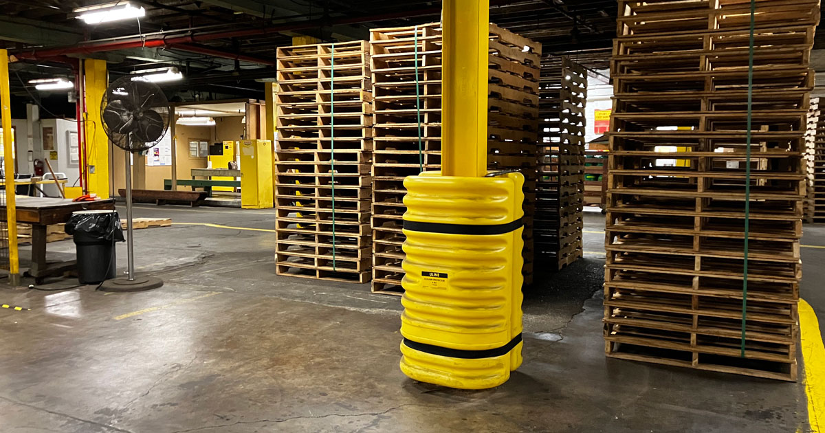 Yellow column protector in front of pallets in warehouse