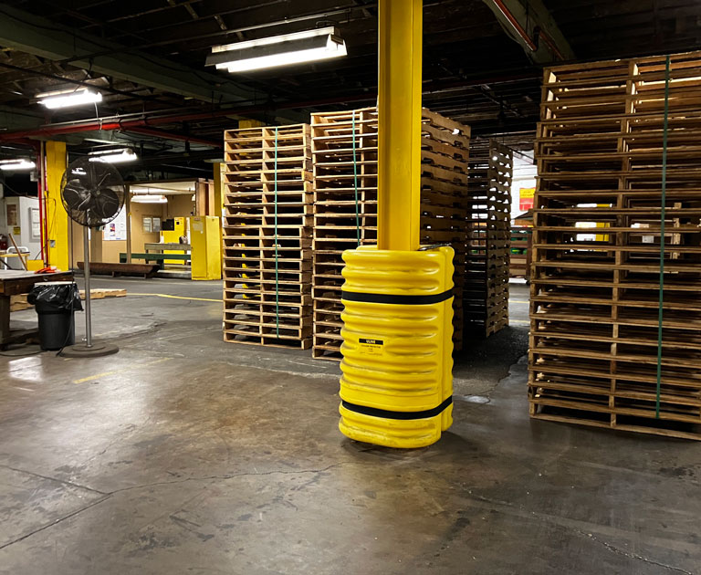 Yellow column protector in front of pallets in warehouse