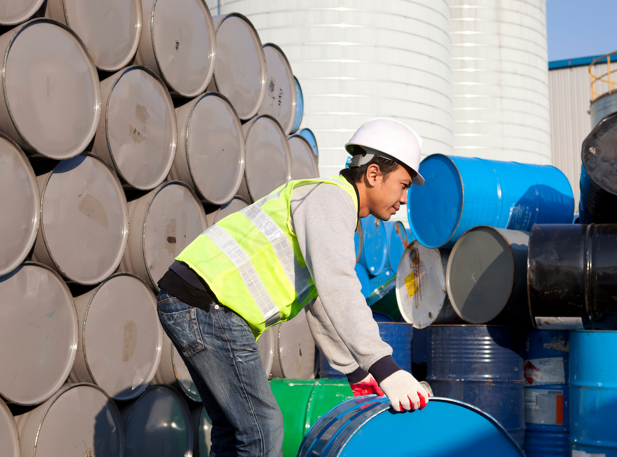 Industrial worker moving 55-gallon steel drum